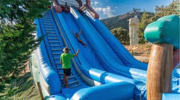 Tobogán hinchable gigante montado en la ladera para una prueba de grupo
