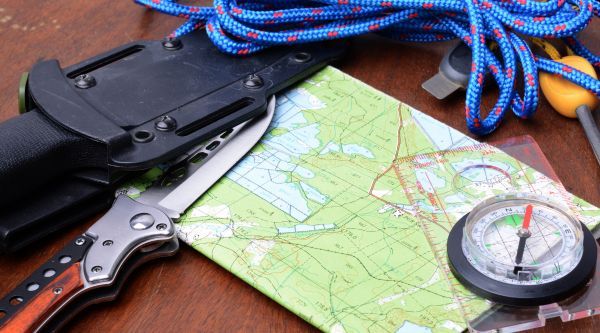 Cuchillo, cuerda, mapa y brújula preparados para las pruebas del raid de supervivencia