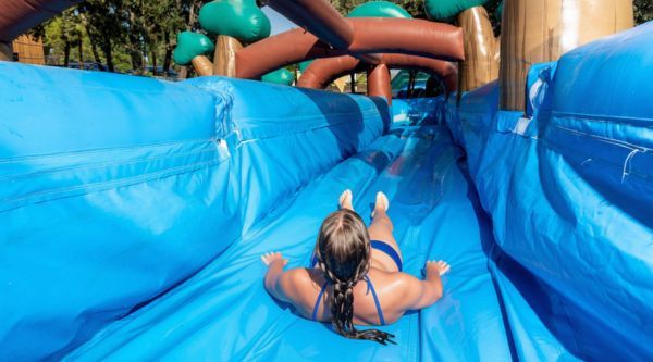 Participante deslizándose de cabeza por un tobogán hinchable