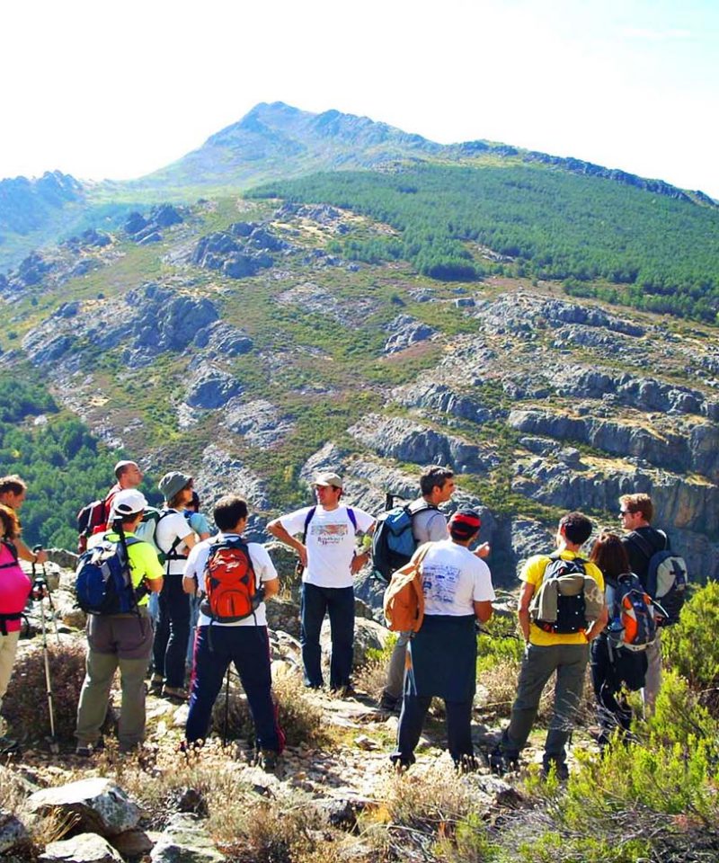 Grupo parado en un collado con la montaña enfrente